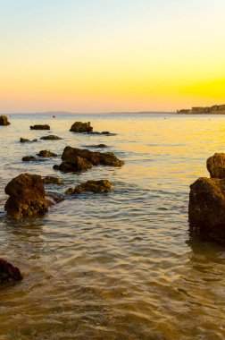 Günbatımında denizin yüzeyindeki tropik mercan resifleri.