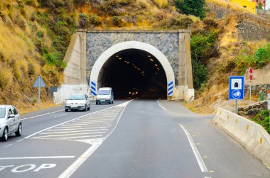 Yoldaki arabalar tünelden geçen dağlar.