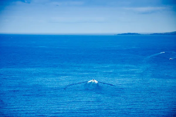 游艇驶入蓝色海的地平线 在水面上留下一条小径 从高处看 — 图库照片