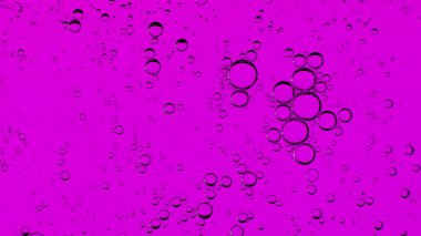 Su yüzeyindeki yağ kabarcıkları hareket halinde, mor bir arkaplan üzerinde, makro, sıçrama ekranı, şablonu, kopyalama alanı