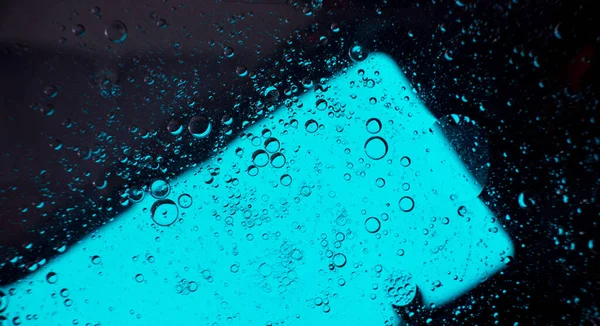 Oil bubbles on the water surface in motion, on a turquoise background, macro, splash screen, template, copy space
