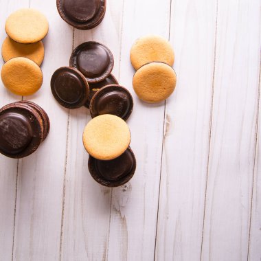 Cookies with chocolate icing on a white table, close-up, copy space, template