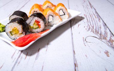 Sushi, beyaz bir tabakta yuvarlan, yakın plan, boşluğu kopyala, şablon