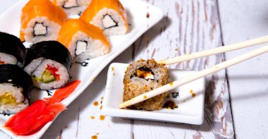 Sushi, beyaz bir tabakta yuvarlan, yakın plan, boşluğu kopyala, şablon