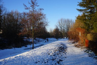 İnsanlar rahatlıyor ve Wuhle Nehri 'nin yukarısındaki donmuş buzun üzerinde spor yapıyorlar. Marzahn-Hellersdorf, Berlin, Almanya  