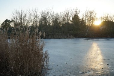 Beautiful sunset over the frozen Wuhlesee lake in February. Marzahn-Hellersdorf, Berlin, Germany 