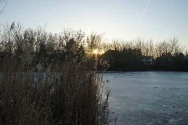 Beautiful sunset over the frozen Wuhlesee lake in February. Marzahn-Hellersdorf, Berlin, Germany 
