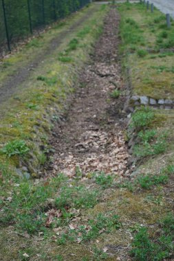 Yol kenarındaki yağmur suyu drenaj sistemi. Marzahn-Hellersdorf, Berlin, Almanya