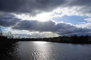 The sun shines through the clouds over the Dahme River in February in the Koepenick district of Berlin, Germany, Europe.