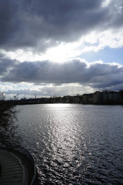 The sun shines through the clouds over the Dahme River in February in the Koepenick district of Berlin, Germany, Europe.