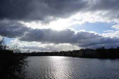 The sun shines through the clouds over the Dahme River in February in the Koepenick district of Berlin, Germany, Europe.