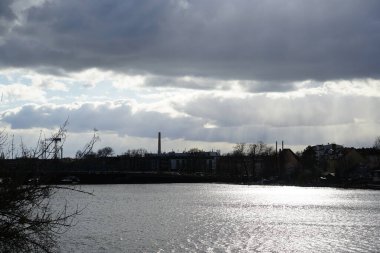 The sun shines through the clouds over the Dahme River in February in the Koepenick district of Berlin, Germany, Europe. 