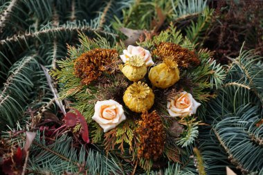 Cenaze düzenlemeleri köknar dallarından yapılır ve yapay ve kurutulmuş çiçekler, böğürtlenler ve diğer dekoratif elementlerle süslenir. Berlin, Almanya, Avrupa.