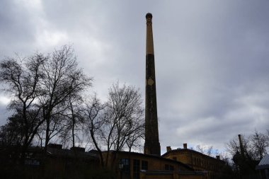 1874 yılında Anhalter Bahnhof 'un eski demiryolu deposunun bulunduğu yerde kırmızı süslemeli sarı tuğladan yapılmış tarihi bir sanayi bacası bulunmaktadır. Deutsches Technikmuseum, Kreuzberg, Berlin, Almanya.