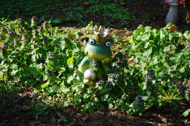 Nisan ayında Lamium purpureum çiçeklerinin arasına bir kurbağa prens ve mantar heykelcikleri yerleştirilir. Lamium purpureum (ayrıca kırmızı ölü ısırgan otu, mor ölü ısırgan otu ya da mor başmelek olarak da bilinir), her yıl yetişen bir bitkidir..