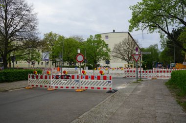 Berlin, Almanya - 5 Mayıs 2023: Kaulsdorfer caddesinde kırmızı ve beyaz yol bariyerleri ve trafik işaretlerinden oluşan geçici inşaat bariyerleri.