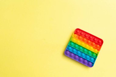 Stres önleyici oyuncağı sarı arka plana yerleştir..