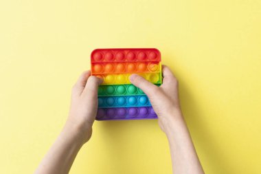 Stres önleyici oyuncağı sarı arka plana yerleştir..