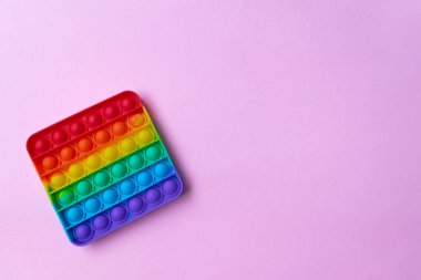 Stres önleyici oyuncağı pembe arka planda salla.