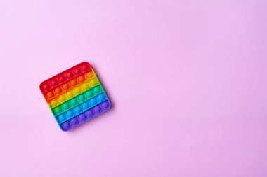 Stres önleyici oyuncağı pembe arka planda salla.