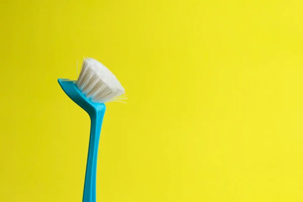 House cleaning scrubbing brush tool on yellow background.