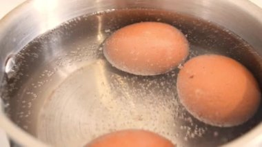 Tavuk yumurtaları paslanmaz çelik tavada kaynıyor.