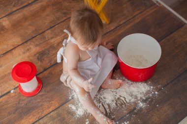 Ahşap arka planda küçük bir bebek şef. Önlükle. Kapatın. Makro fotoğraf. 