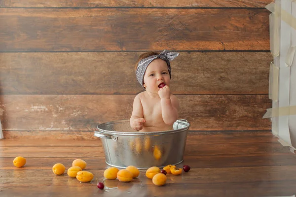 Ragazza di un anno si bagna con frutta. — Foto Stock