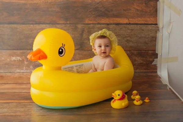 Una niña de un año se baña. Con pato amarillo. — Foto de Stock