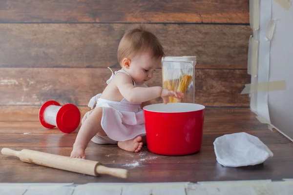 Pequeño bebé chef sobre fondo de madera. En delantal. — Foto de Stock