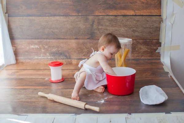 Pequeño bebé chef sobre fondo de madera. En delantal. — Foto de Stock