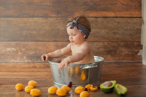 Ragazza di un anno si bagna con frutta. — Foto Stock