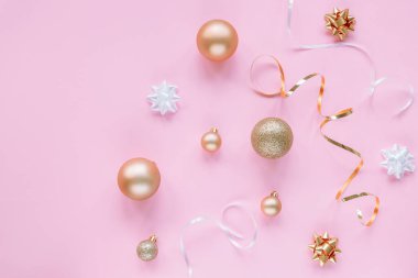 Beyaz ve altın Noel topları, süsler ve mücevherlerle dolu pembe şenlikli bir arka plan. Üst görünüm, düz görünüm, kopyalama alanı