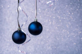 Dvě modré vánoční koule na stříbrném pozadí bokeh. Minimální zimní složení. Nový rok koncept, kopírovací prostor.