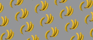 Gri arka planda sarı muzlar, doku. Düz yatıyordu