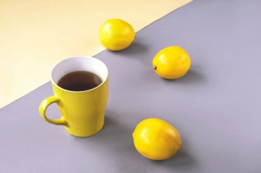 Sarı çay ve gri arka planda limon. Moda Renkleri 2021