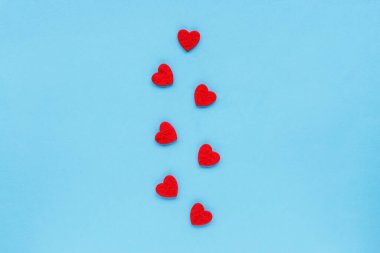 Kırmızı kalplerin süslemesi mavi arka planda, üst manzara, düz yatış. Sevgililer Günü konsepti.