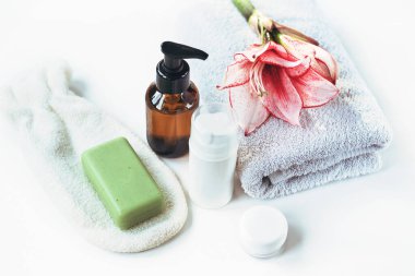 Kozmetik ürünleri, cilt toniği, havlu ve el yapımı sabun beyaz masada. Spa tedavileri ve cilt bakımı kavramı.