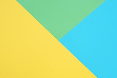 Yeşil, sarı ve mavi renkli kağıtlar. Geometrik boş kağıt arkaplanı, kopyalama alanı.