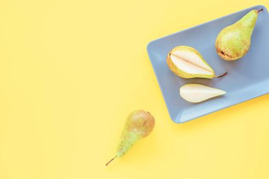 Sarı bir zemin üzerinde olgun armutlar, üst görünüm, düz yatış.