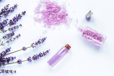 Lavanta çiçeği, deniz tuzu ve temel yağ beyaz arka planda, üst görünüm, düz yatıyordu.