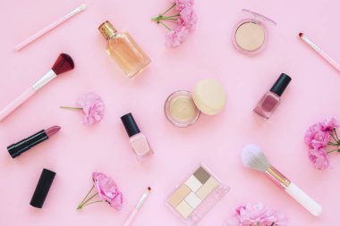 Pembe arka planda makyaj ürünleri. Üst manzara, düz yatış. Moda, güzellik konsepti
