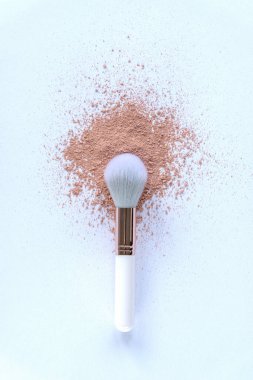 Beyaz arka planda serpiştirilmiş toz ile makyaj fırçası. Üst manzara, düz uzanma.