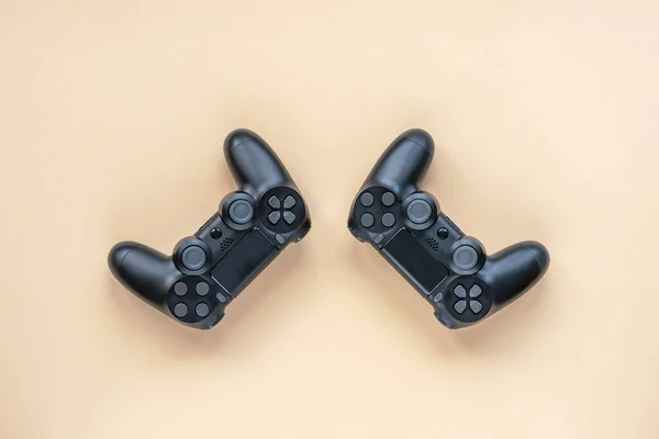 两个游戏控制器 一个电子游戏控制台或Pc无线黑的浅橙色背景 顶部视图 — 图库照片