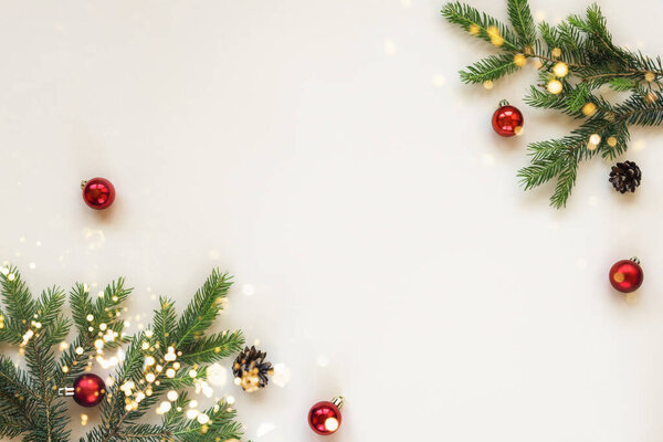 Christmas festive background fir branches and red Christmas balls on beige background. Top view, flat lay, copy space.