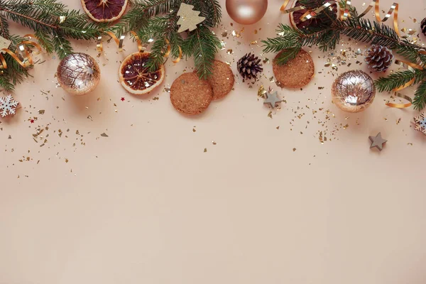Weihnachtlicher Hintergrund Weihnachtsbaumzweige Kugeln Plätzchen Und Goldenes Konfetti Auf Beigem — Stockfoto
