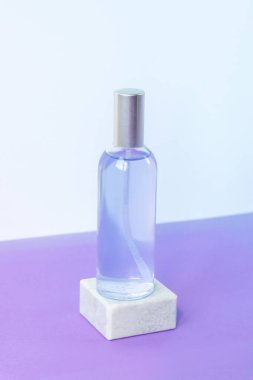 Lavanta suyu ya da cam şişede su, mor masada gri podyumda. Aromaterapi konsepti. Model.