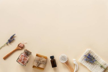 Banyo aksesuarları ve doğal kozmetik ürünleri, cam kavanozda himalaya pembe tuzu, esaslı yağ, sabun ve bej arka planda lavanta çiçekleri. Sıfır atık. Üst görünüm, düz görünüm, kopyalama alanı