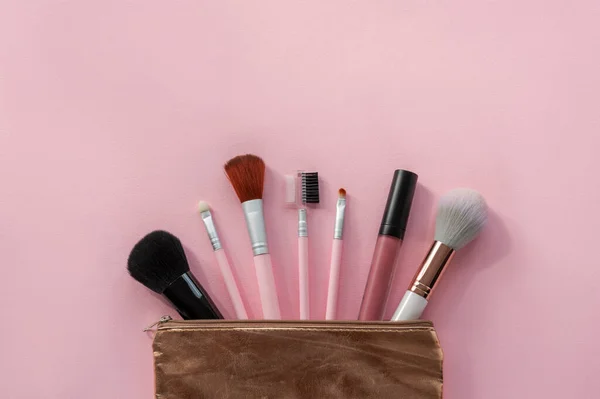 Kolekcja Pędzli Makijażu Szminki Złotej Kosmetycznej Torbie Różowym Tle Piękno — Zdjęcie stockowe