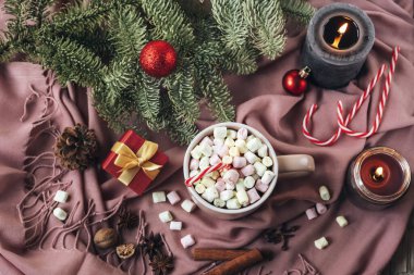 Noel 'de kakao fincanı, marşmelov, pembe fular, köknar dalı, mum ve bir kutuda hediyeyle yatıyordu. Üst Manzara. Kış konsepti.